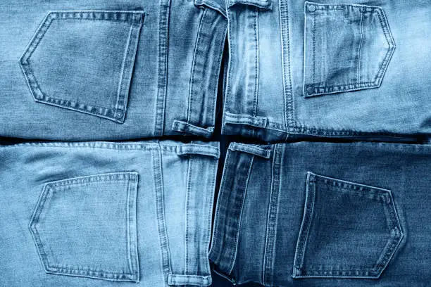 Fashion collection denim blue jeans stacked. Creative jeans background. Top view, flat lay. Color of the year 2020 classic blue toned.