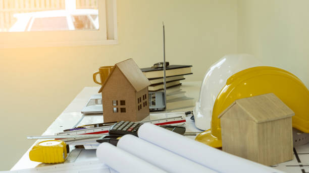 istock House designs and hats of engineers' notebooks on the table . 1196494003