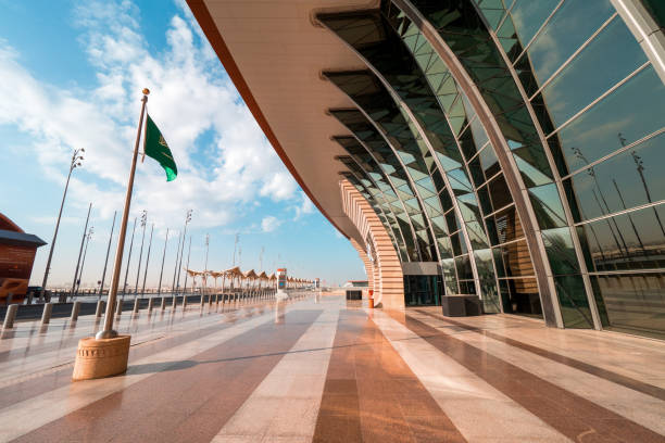 Saudi flag waving in the wind in front of the brand new Terminal 1 at the King Abdulaziz International Airport (JED) in Jeddah, Saudi Arabia Jeddah, KSA - December 19th 2019: Exterior view of the new terminal in Jeddah during a test run in December 2019. Soon, masses of people will pass this terminal. jeddah stock pictures, royalty-free photos & images