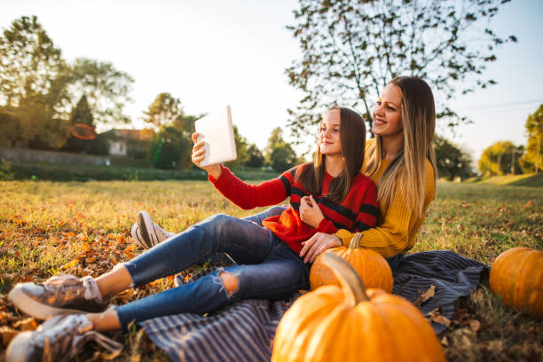 istock Beautiful sisters making selfie in nature on sunny autumn day 1196496802