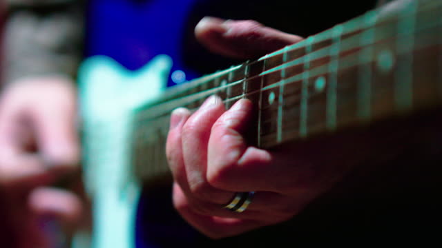 The closeup video of the man playing guitar