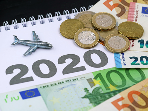 airplane moneyairplane with euro banknotes and coins, money on calendar, concept of increasing air traffic in 2020.