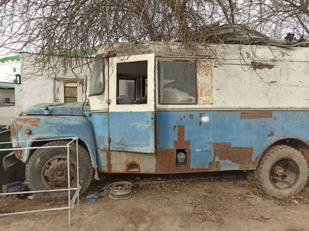 istock an old two-tone abandoned bus covered in rust 1196499904