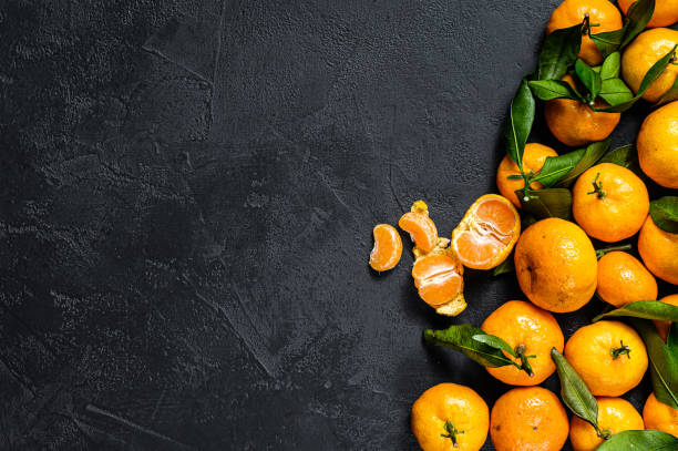 istock Tangerines, mandarines  with leaves. Black background. Top view. Space for text 1196504028