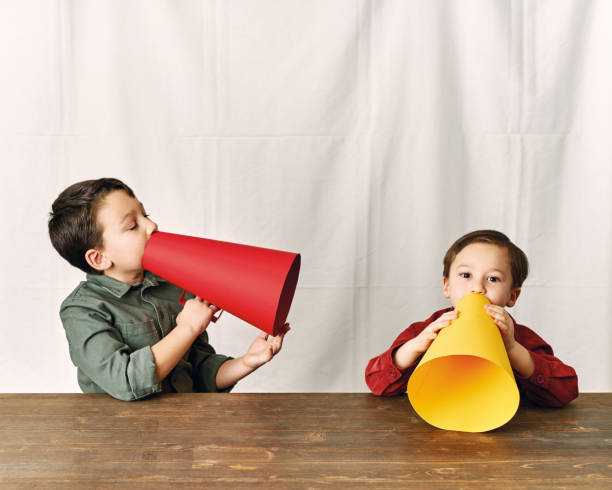 istock Two children are talking with paper megaphone 1196505039