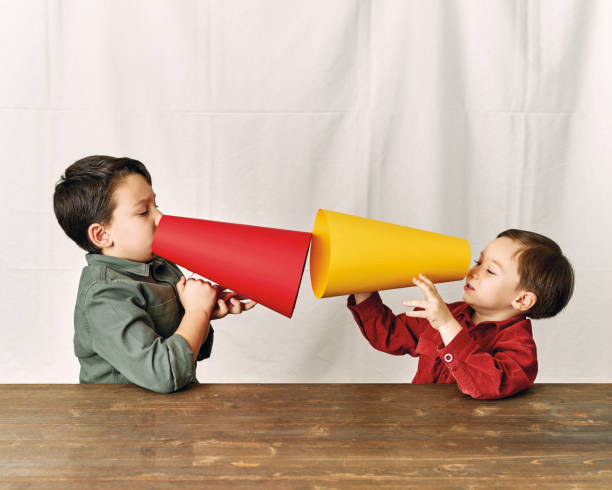 istock Two children are talking with paper megaphone 1196505047