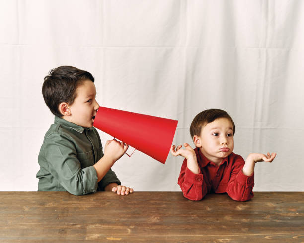 istock Two children are talking with paper megaphone 1196505066