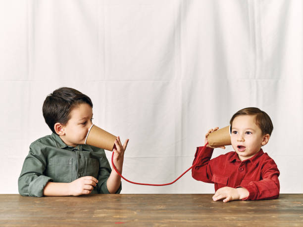 Two childeren are using paper cups as a telephone. Two childeren are using paper cups as a telephone. toy phone stock pictures, royalty-free photos & images