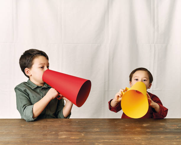 istock Two children are talking with paper megaphone 1196505074