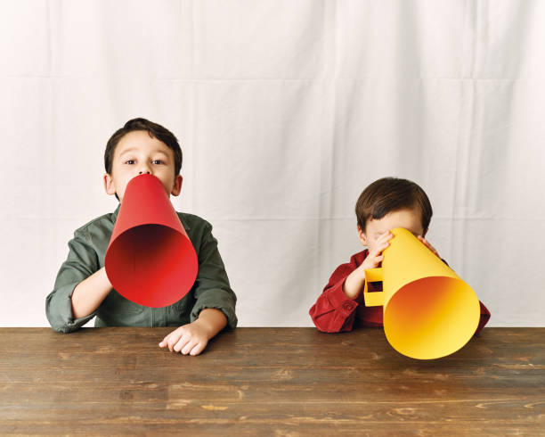 istock Two children are talking with paper megaphone 1196505088