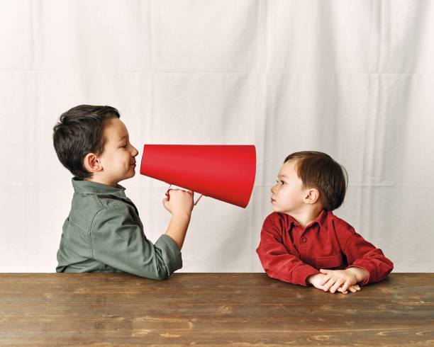 istock Two children are talking with paper megaphone 1196505153