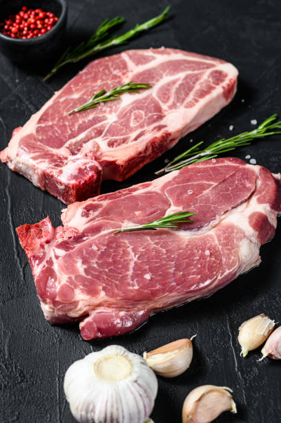 istock Fresh pork steak. Marbled meat. Black background. Top view 1196505681