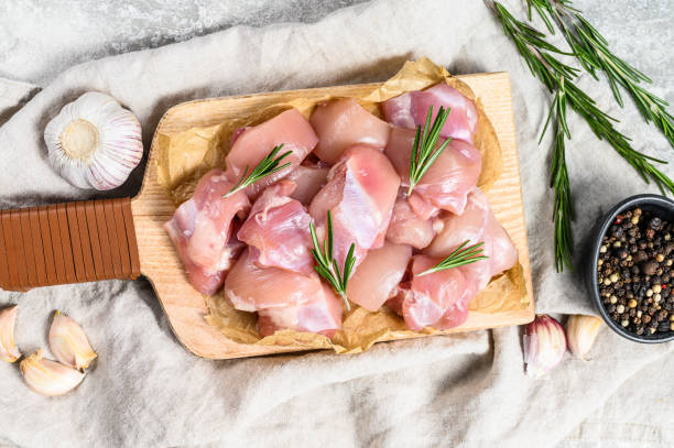 filete de muslo de pollo cortado en cubos. fondo gris. vista superior - skinless chicken breast fotografías e imágenes de stock