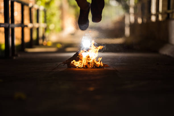 A man is jump cross the bonfire.