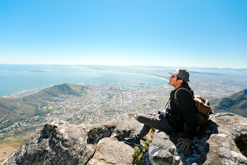 south Africa, Cape Town, man standing looking at the coast during hiking trip to Lion's Head