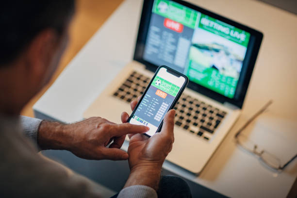 istock Watching football match on computer and betting 1196509940