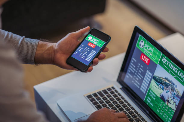istock Watching football match on computer and betting 1196509998