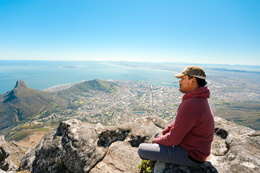 south Africa, Cape Town, man standing looking at the coast during hiking trip to Lion's Head