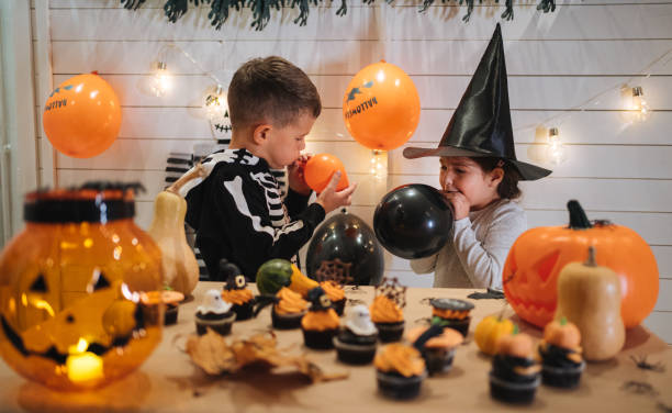 istock Kids blowing balloons for Halloween 1196511577