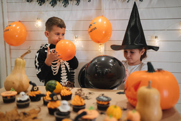 istock Playful kids blowing balloons for Halloween 1196511595