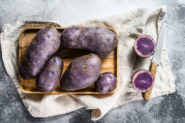 istock Raw purple potatoes on a chopping Board. Gray background. Top view. Space for text 1196511852