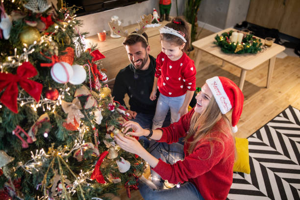istock Happy family decorating Christmas tree together 1196512799