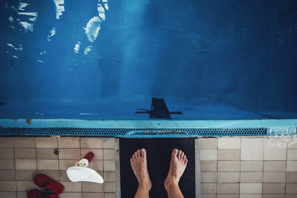 Mature swimmer standing on a diving board Mature man, relaxing by the pool, swimming, and stretching floating dock stock pictures, royalty-free photos & images