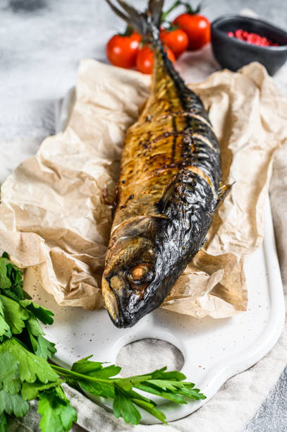 istock smoked mackerel with parsley and cherry tomatoes. Gray background. Top view 1196513991