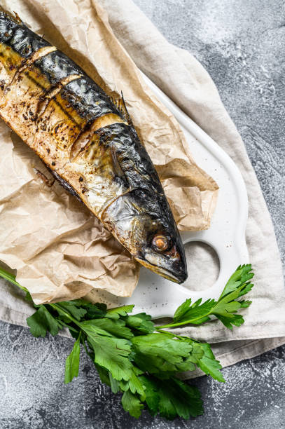 istock Grilled mackerel with parsley and cherry tomatoes. Gray background. Top view 1196514703