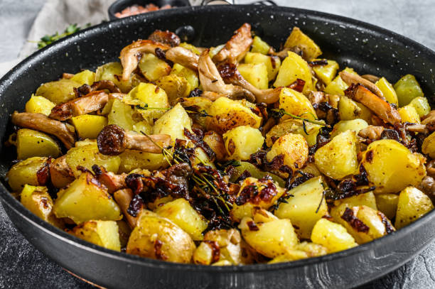 istock Fried oyster mushrooms with potatoes in a pan. Gray background. Top view 1196517355