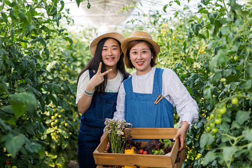 A woman and her teenage daughter working together on the family farm.