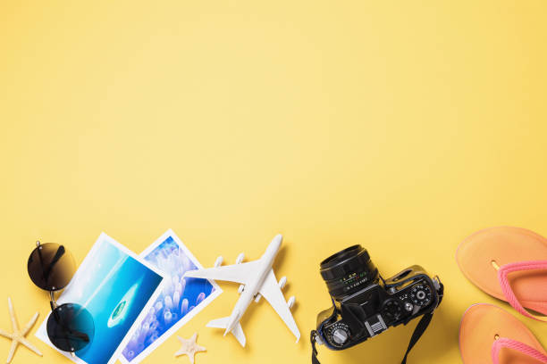toy airplane, glasses, photos and camera on a yellow background with copy space. concept for traveling in exotic places - shell sea souvenir island imagens e fotografias de stock