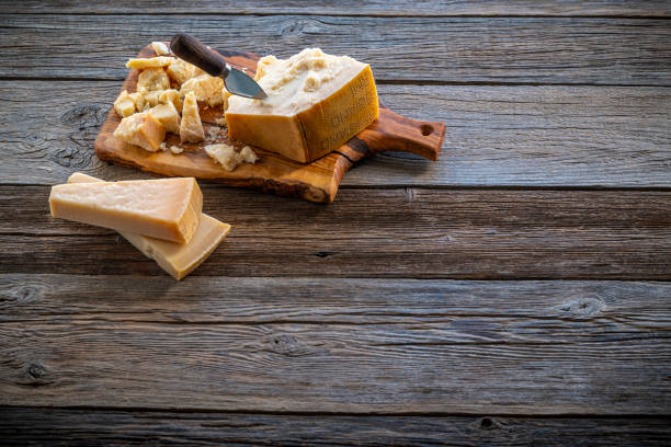 Parmesan Reggiano cheese on cutting board and knife at wooden table