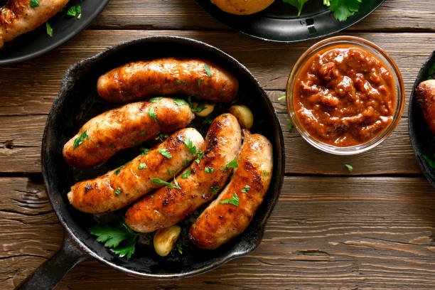 Grilled sausages Fried sausages in frying pan over wooden background. Top view, flat lay sausage stock pictures, royalty-free photos & images