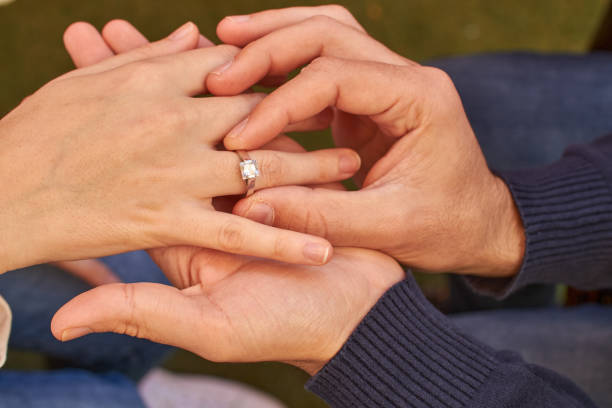 istock Man hands putting ring on woman 1196534593