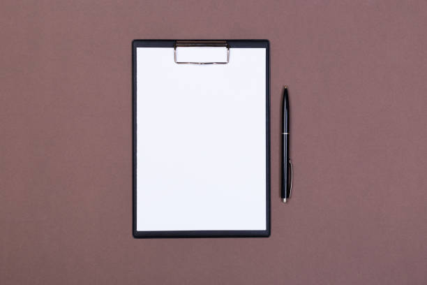 istock Clipboard with white sheet and pen on a colored background. View from above. space for text 1196535398