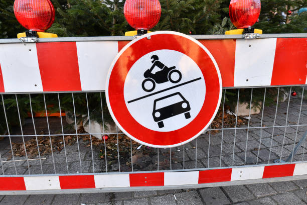 rouge rond 'pas d'accès au signe de route de véhicules à moteur' sur la barrière de métal rouge devant le marché de noel dans le centre-ville - curve road in front of sign photos et images de collection