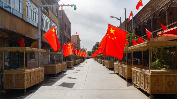 strada con bancarelle nel centro storico di kashgar, bandiere cinesi su ogni stand (xinjiang, cina) - uighur foto e immagini stock