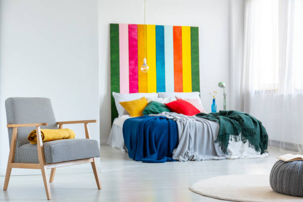 istock Retro armchair in modern bedroom interior with rainbow colored headboard 1196542595