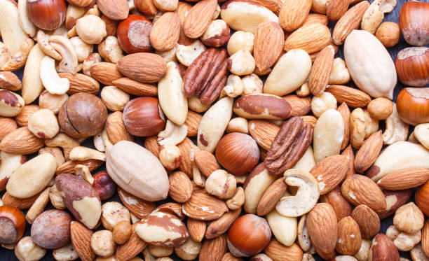 istock Background and texture made from different kinds of nuts. hazelnut, brazil nut, almond, pumpkin seeds, cashew.  top view. 1196548141