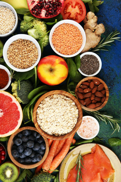 istock Healthy food clean eating selection: fish, fruit, vegetable, cereal, leaf vegetable on rustic background 1196549067