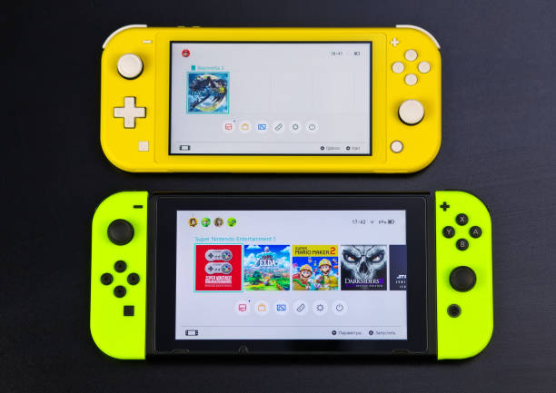 Nintendo Switch and small Nintendo Switch Lite. Comparison of two handheld game consoles MOSCOW, RUSSIA - October 10, 2019: Nintendo Switch and small Nintendo Switch Lite. Comparison of two handheld game consoles brand name games console stock pictures, royalty-free photos & images
