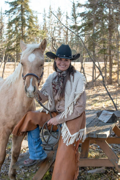 istock Cowgirl next to a blond colored colt 1196553234