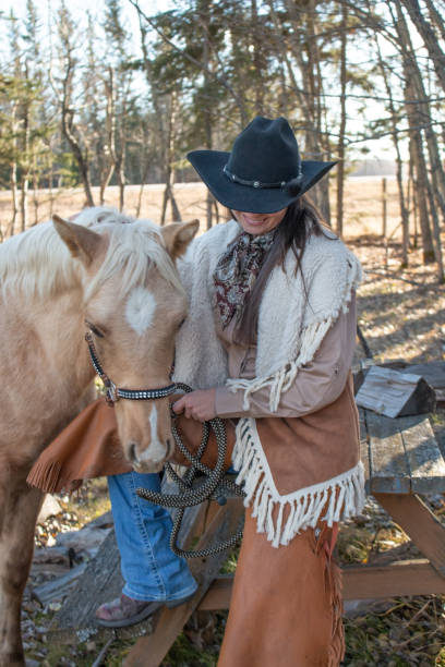 istock Cowgirl next to a blond colored colt 1196553236