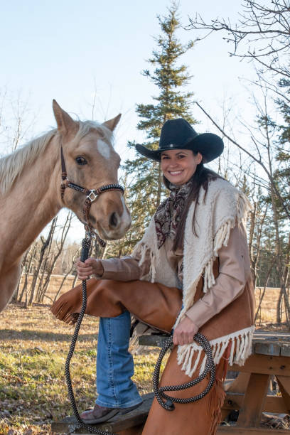 istock Cowgirl next to a blond colored colt 1196553256