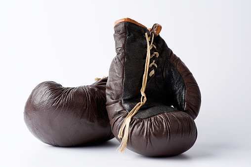 pair of vintage brown leather boxing gloves on a white background, sports equipment. Fitness gym background.