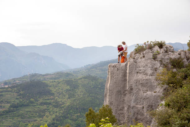 istock Father and son pause on hike at edge of vertical cliff 1196559089