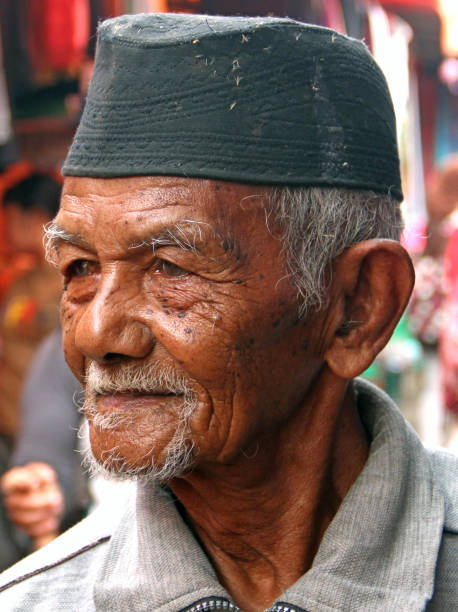 Bukittingii, Indonesia - July 25, 2010. An elderly Indonesian man walking through a market in Bukittinggi in West Sumatra, Indonesia.