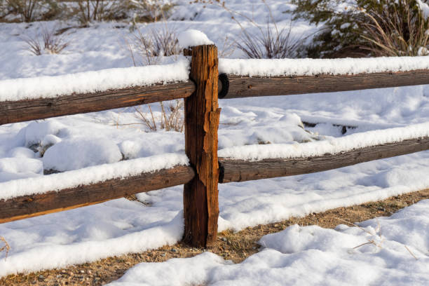Snow on a red wooden fence. First snow. Precipitation after a snowstorm. Winter background, space for text.