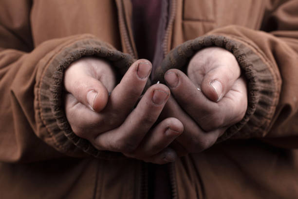 istock beggar concept. poor man asks for cash assistance. silver coins in the palms 1196568757